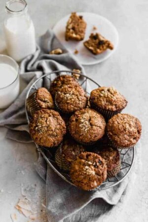Morning glory muffins in a serving tray with glasses of milk on the side.