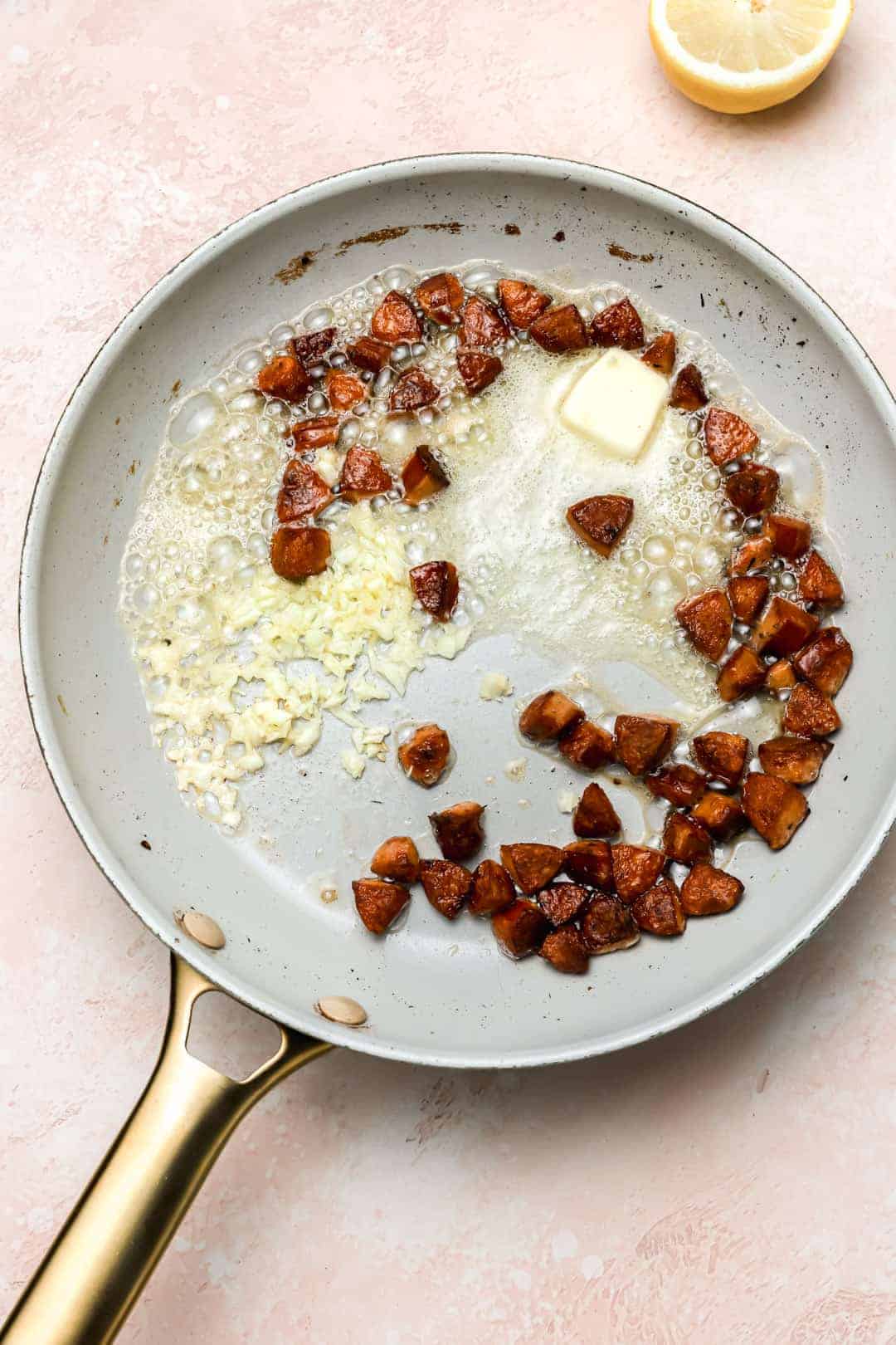 Andouille sausage with garlic and butter in a skillet