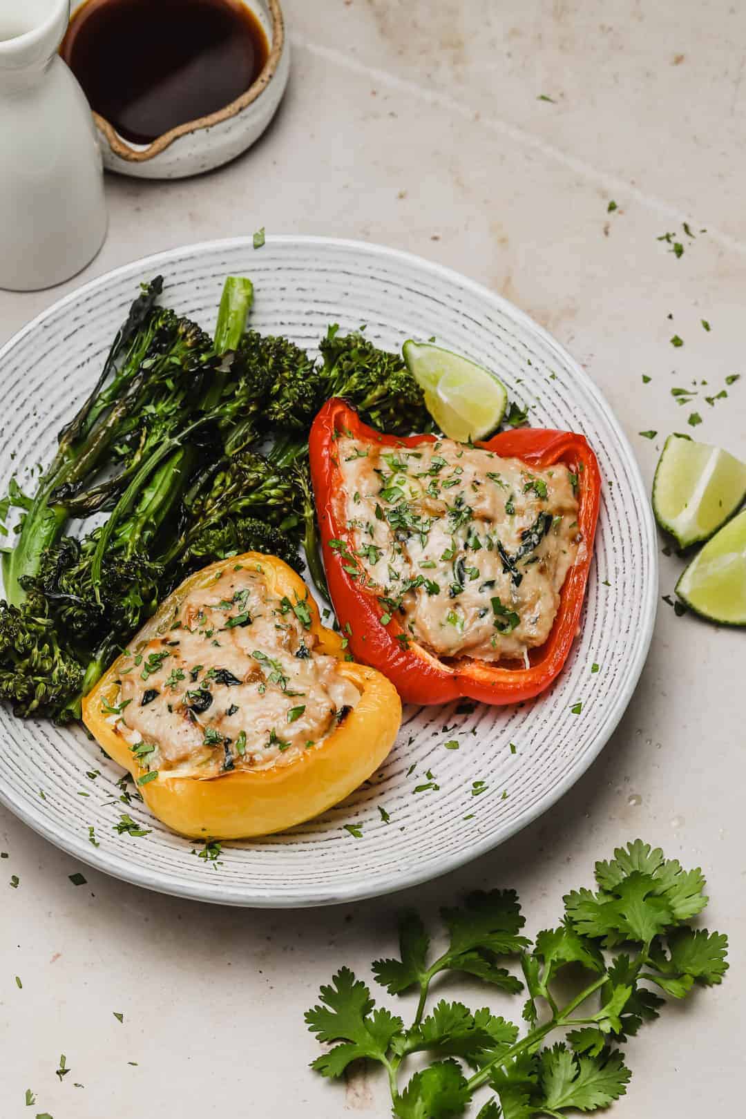 Stuffed peppers with ground chicken on a plate with broccolini