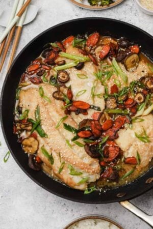 Miso cod in a skillet with scallions.