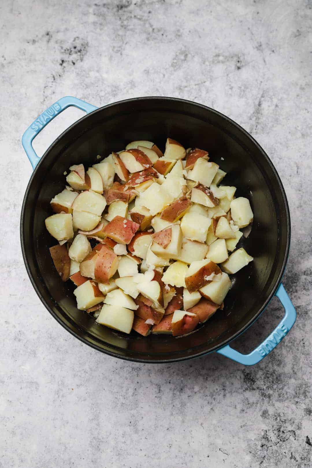 Boiled red skin potatoes in a pot, ready to be mashed.