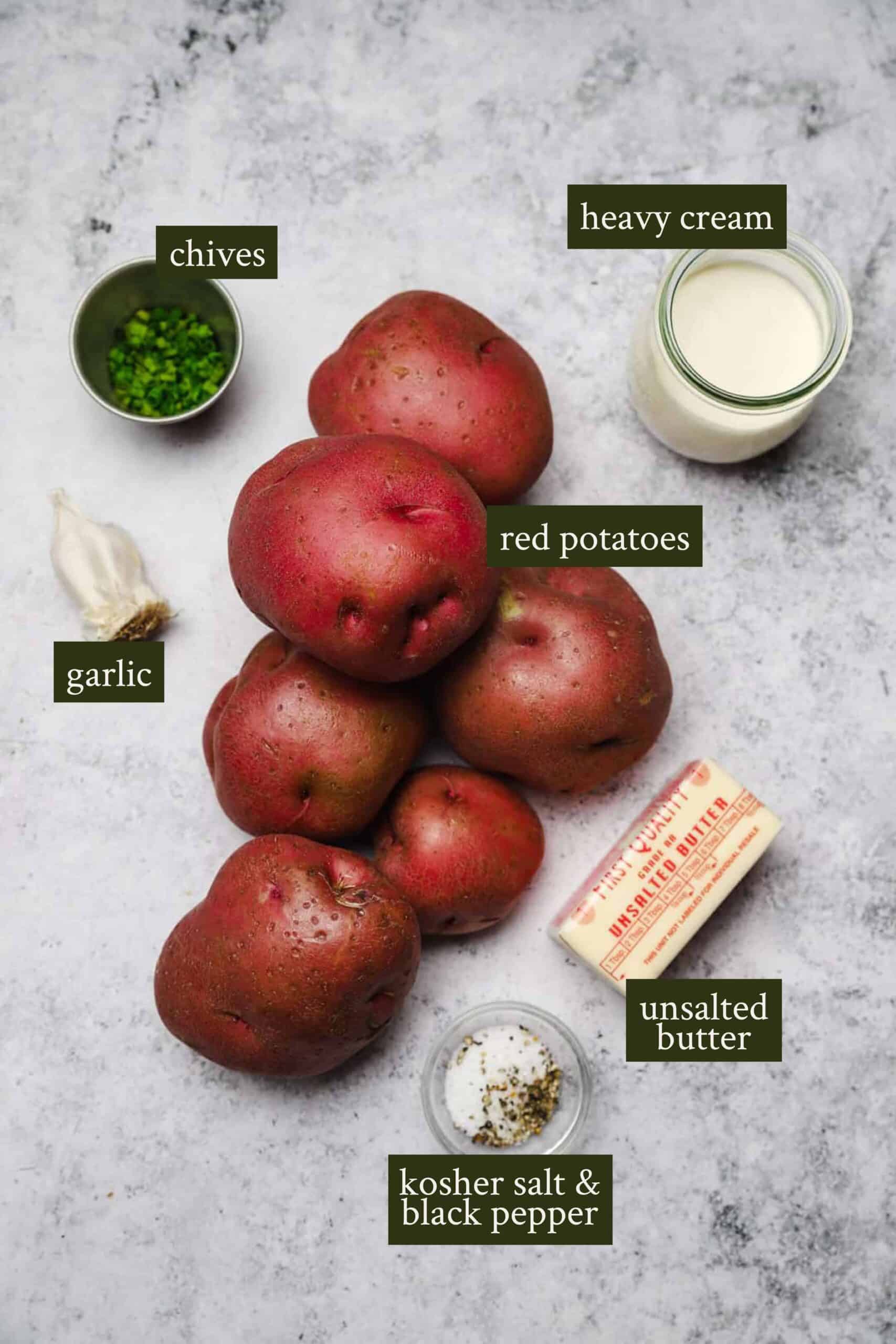 Ingredients for red skin mashed potatoes: red potatoes, butter, garlic cloves, heavy cream, chives, and salt.