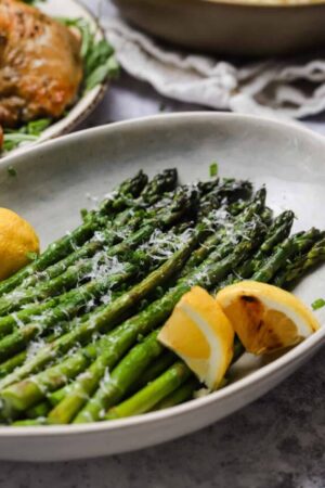 Grilled asparagus with lemon in a bowl.