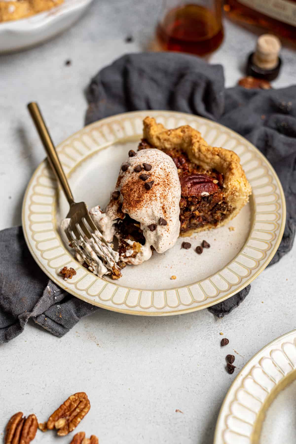 Slice of chocolate pecan pie on a plate with wihpped cream