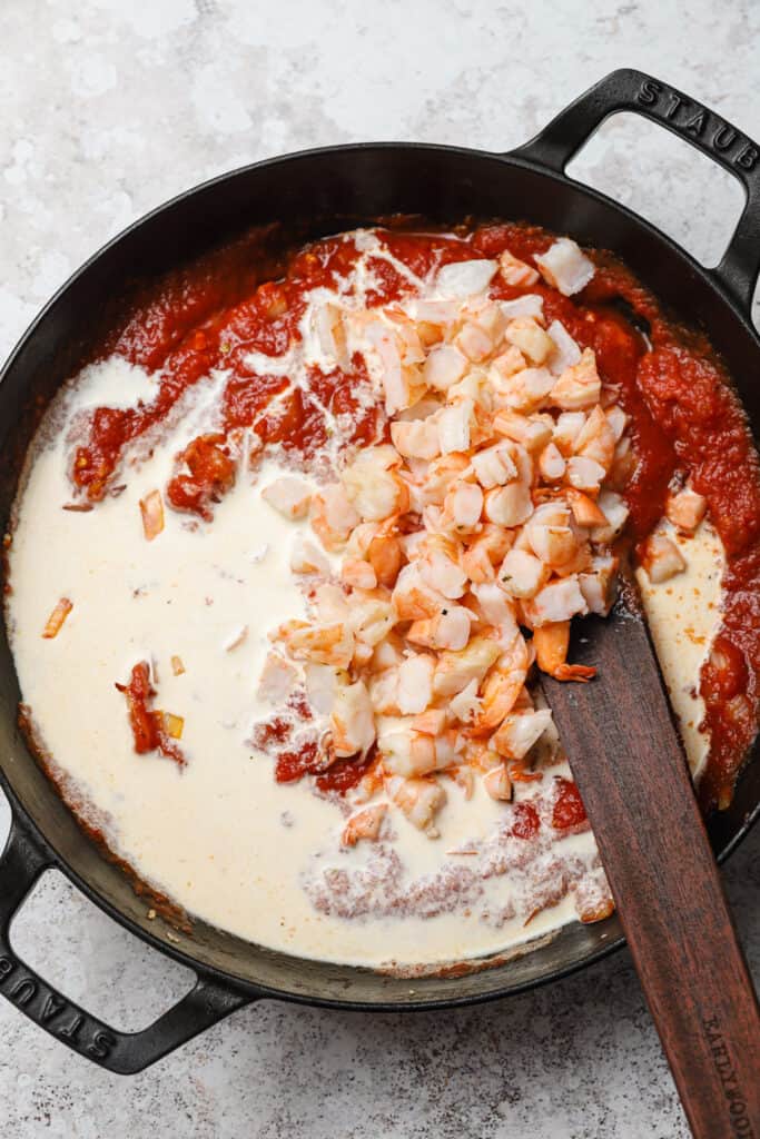 Shrimp simmering in creamy vodka sauce with tomatoes.
