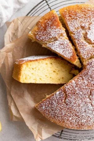Sliced olive oil and lemon cake on a wire rack.