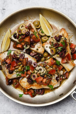 Pan seared swordfish steaks with olive and tomato relish on top.