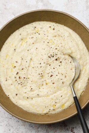 Creamy parsnip purée in a bowl with a spoon.