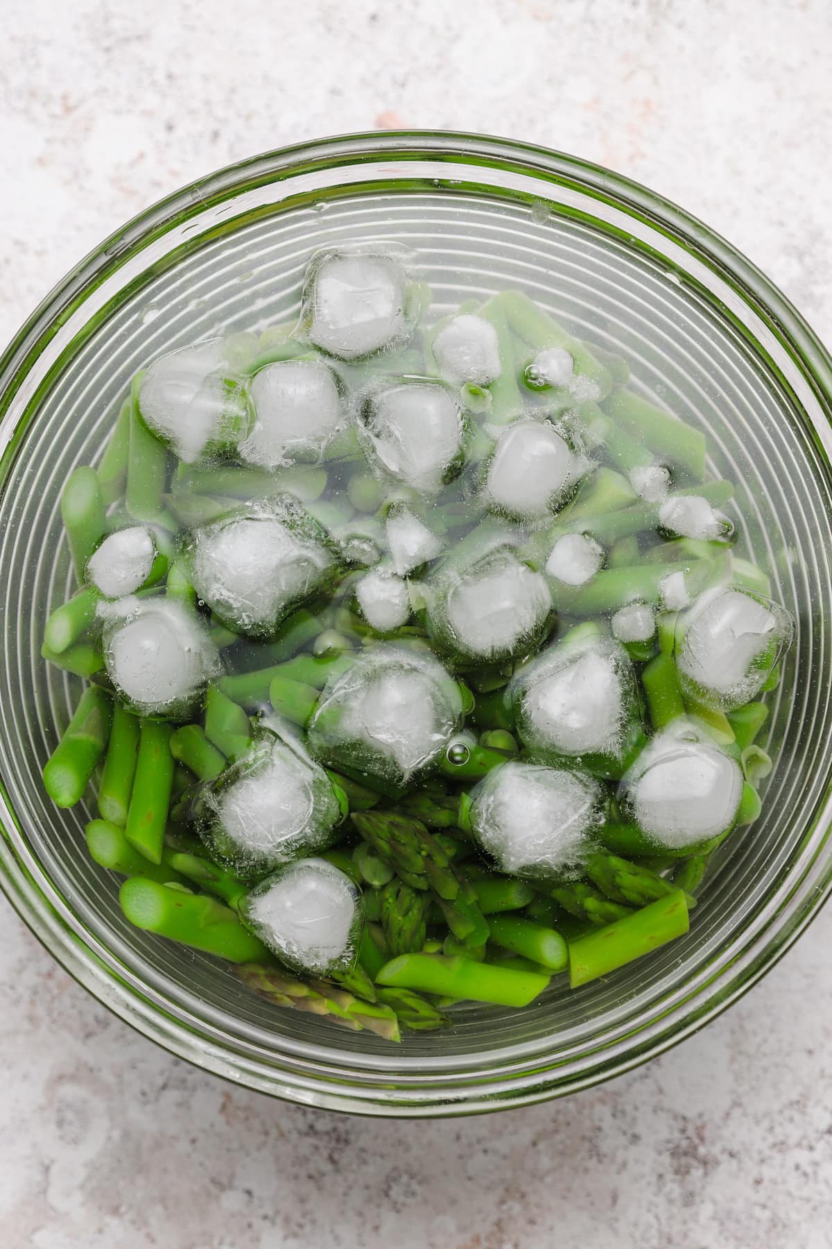 Asparagus and fresh peas in an ice bath.