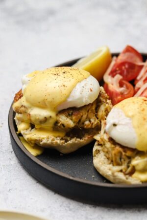 Creamy homemade blender hollandaise on top of poached egg and crab cake benedict.