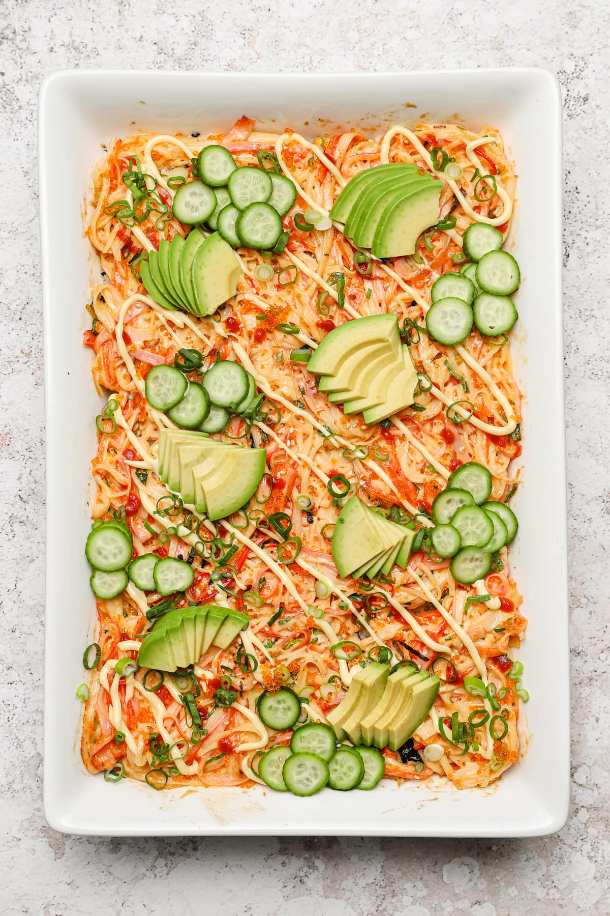Sushi bake casserole with avocado cucumber and spicy mayo.