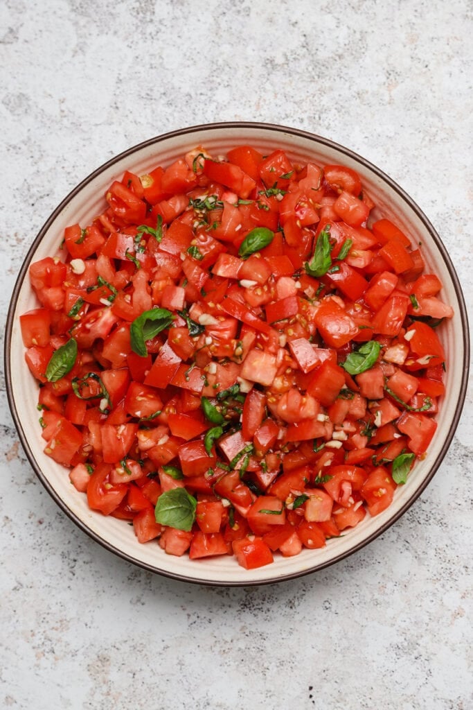 Italian bruschetta in a bowl with fresh basil garnish.