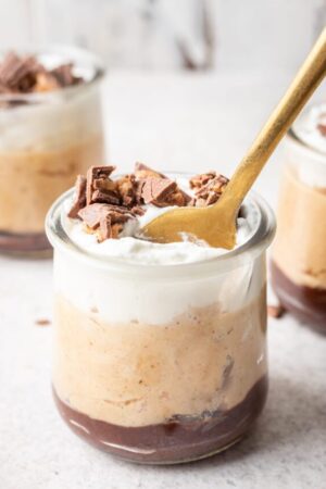 Peanut butter mousse cups with a gold spoon.