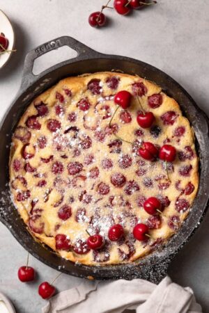 Baked cherry clafoutis in a skillet.