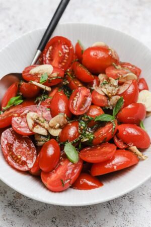 Marinated tomato salad with garlic and balsamic in a bowl.
