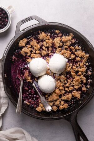 Skillet blueberry crisp with frozen blueberries and vanilla ice cream.