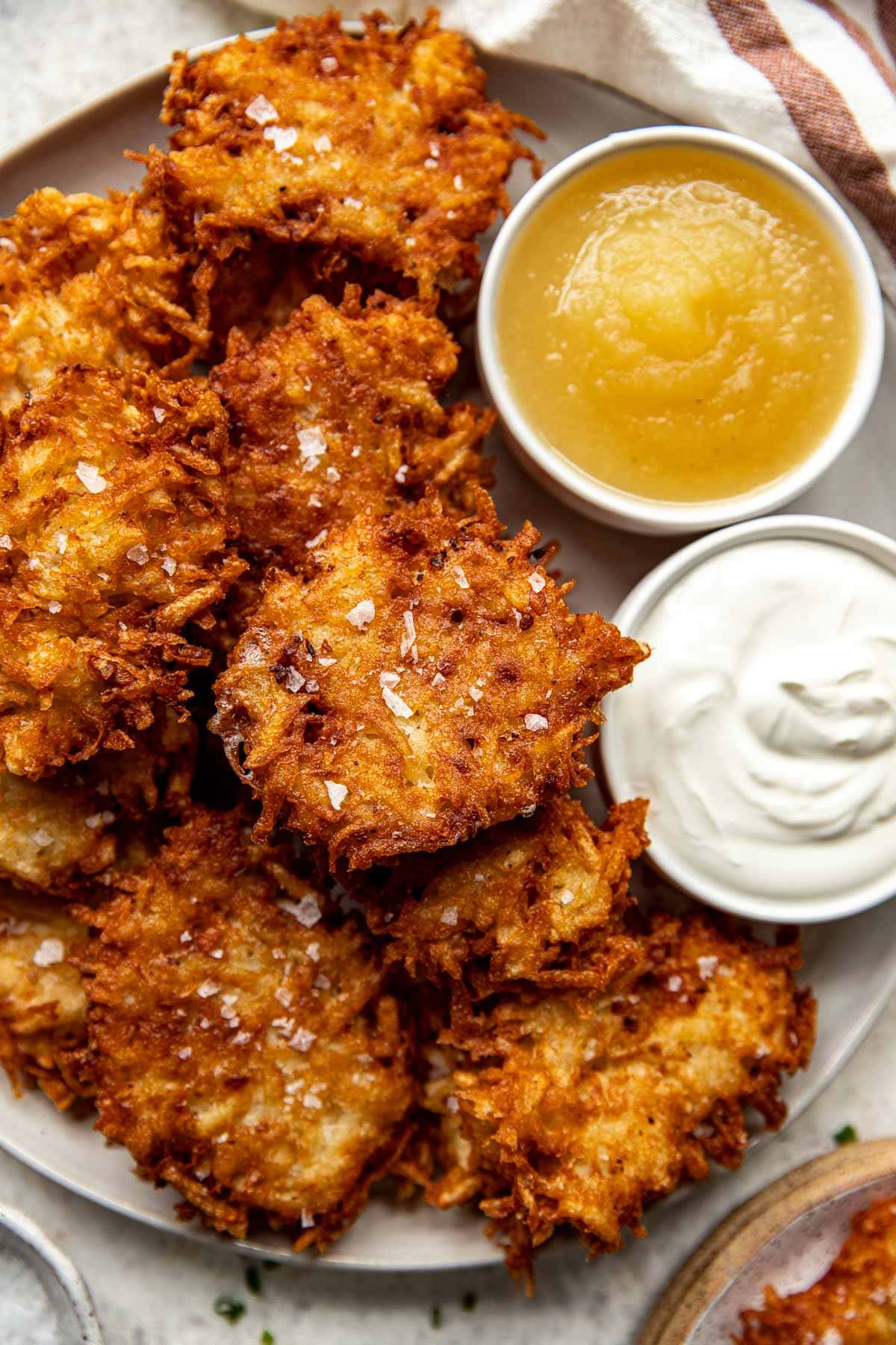 Fried potato pancakes with applesauce and sour cream on a plate.