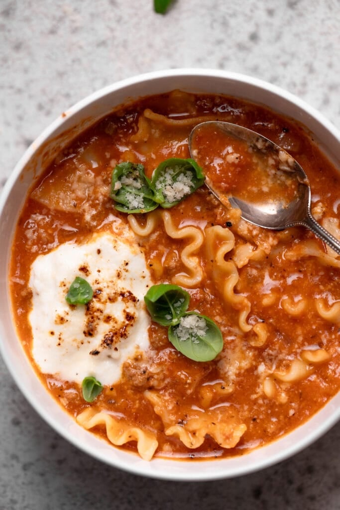 Lasagna soup with broken lasagna noodles fresh basil and Parmesan.