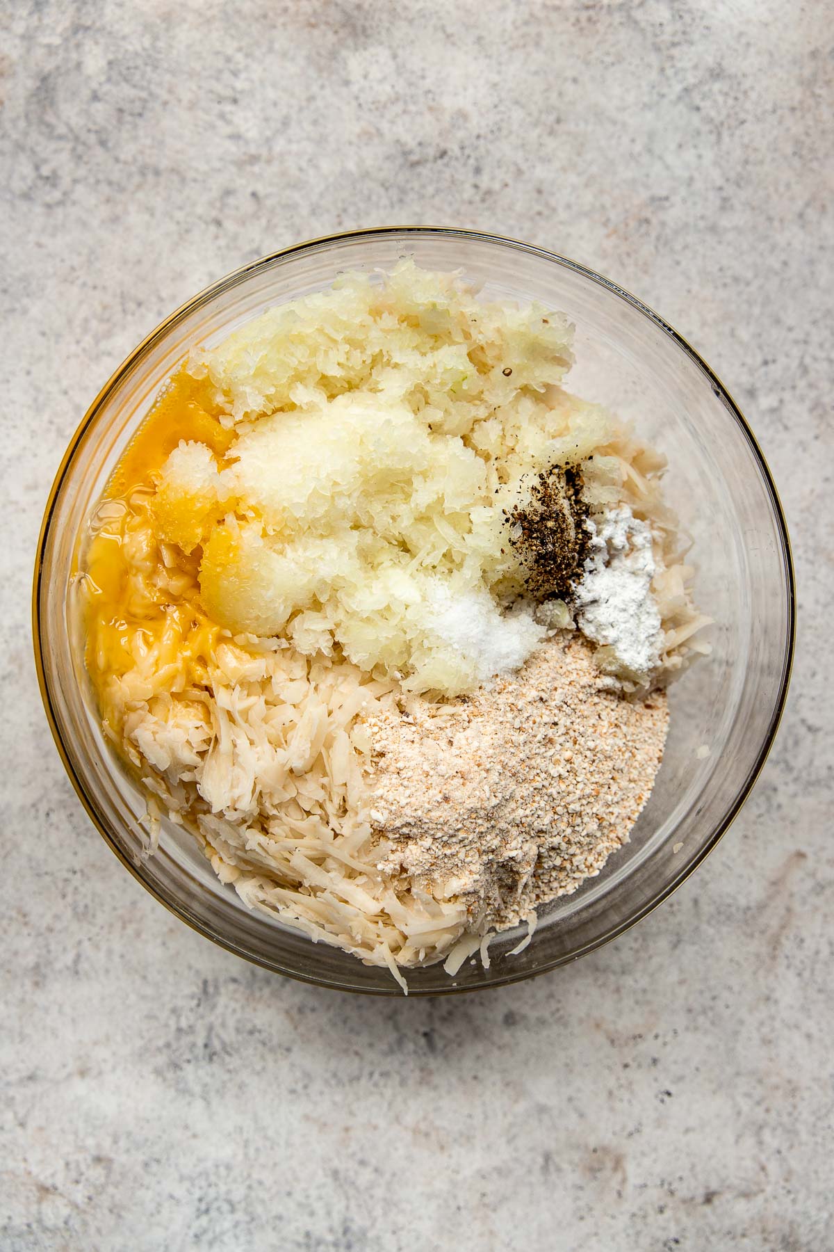 Making potato pancake mixture in a bowl.