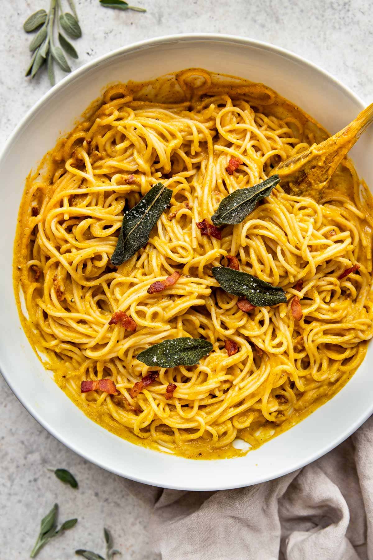 Butternut squash pasta with crispy sage leaves in a large serving bowl.