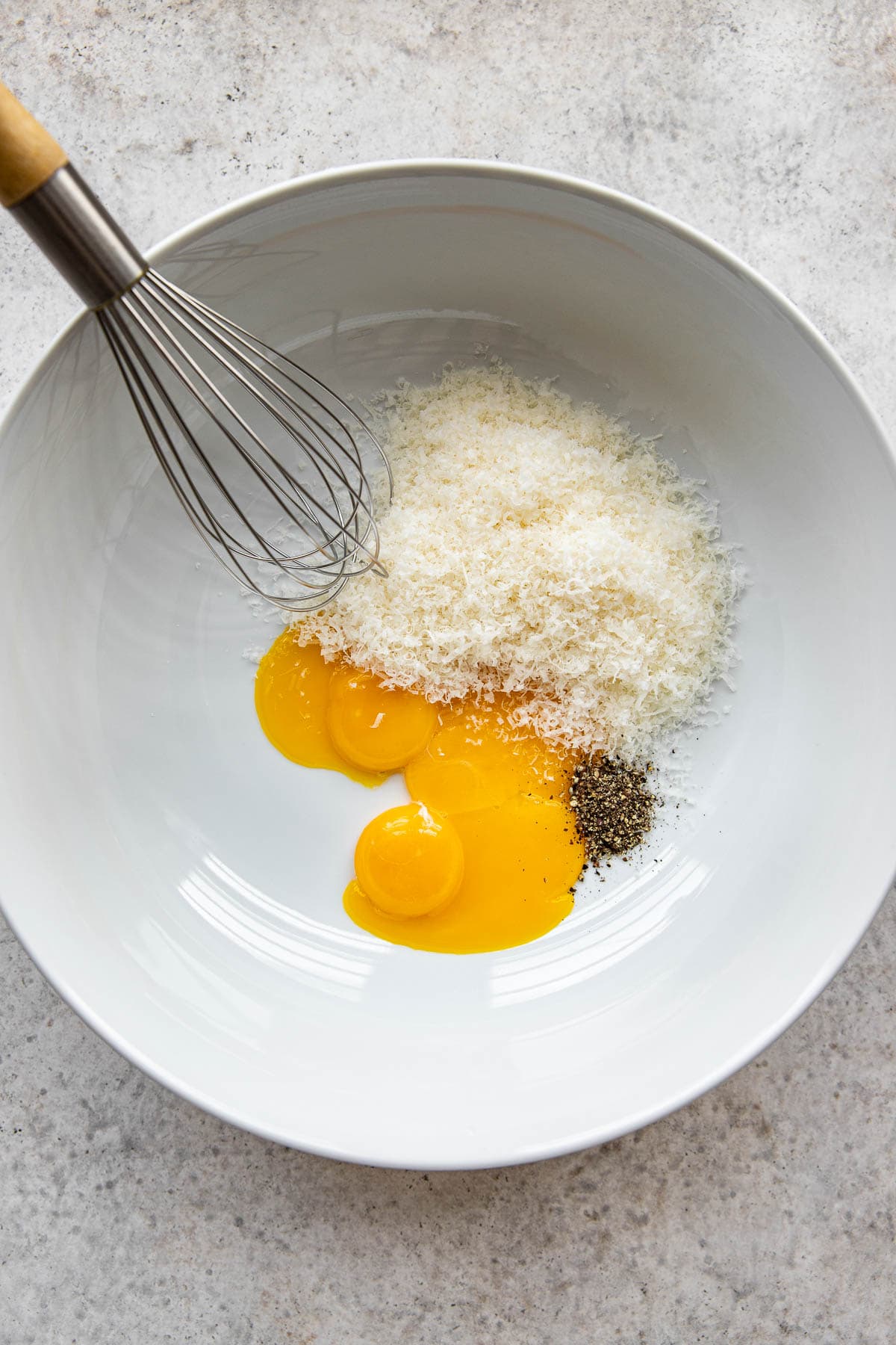 Parmesan cheese and egg yolks in a bowl.