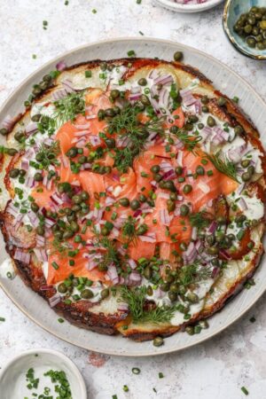 Potato galette recipe with smoked salmon creme fraiche and dill on top.