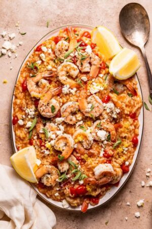Shrimp and feta risotto with tomatoes on a serving platter.