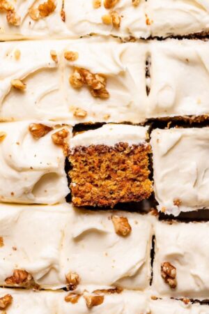 Slice the carrot cake into squares, then serve.
