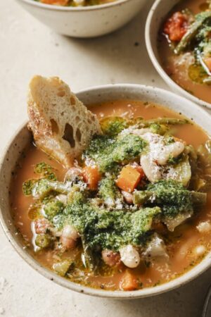 Soupe au pistou in a bowl with pesto sauce on top.