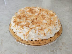 Coconut Cream Pie with toasted coconut flakes on top.