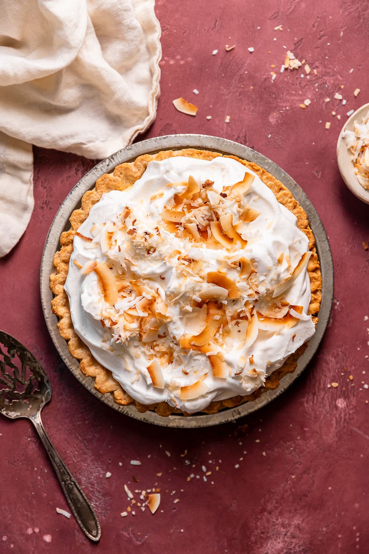 Homemade coconut cream pie with whipped cream and coconut flakes.