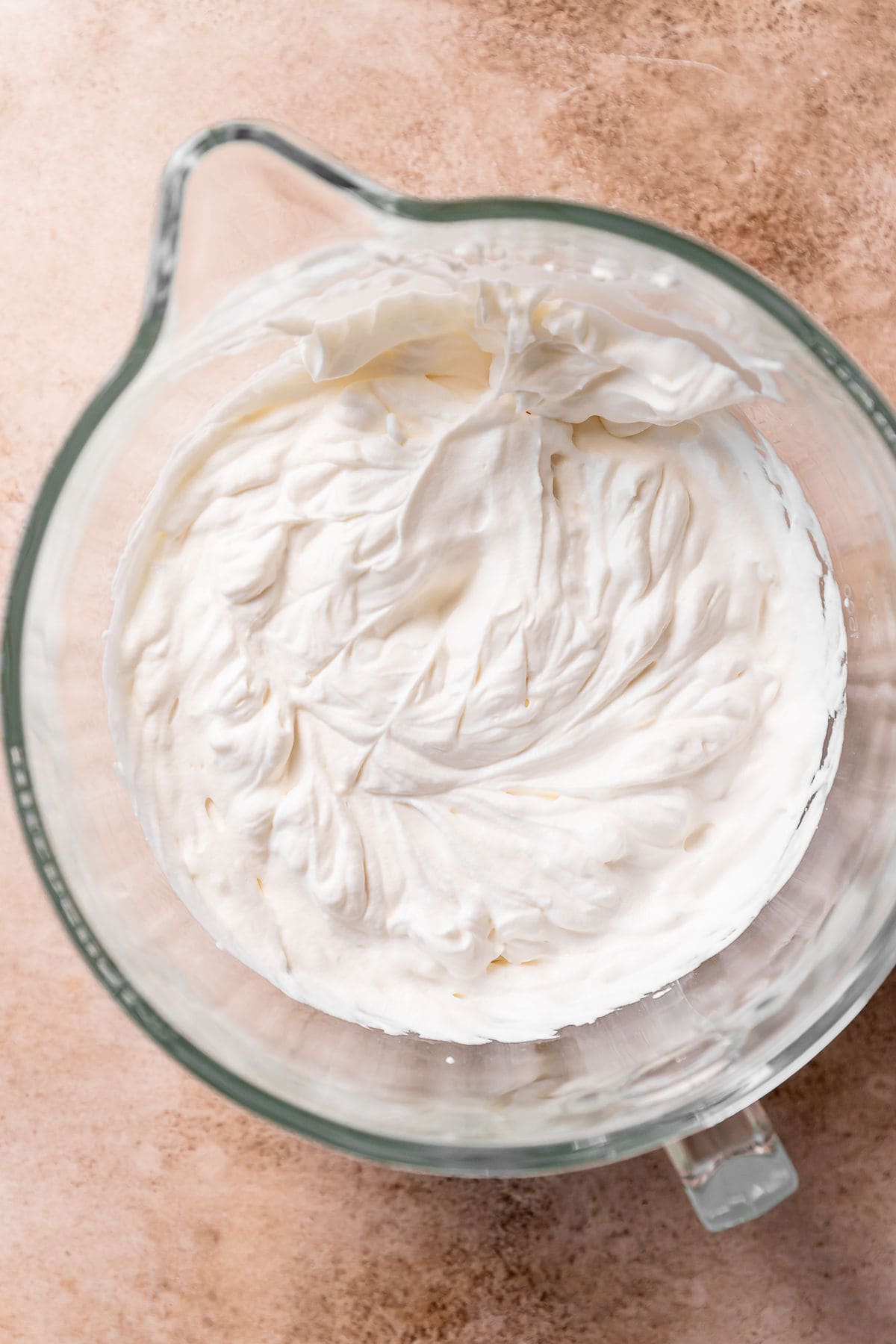 Homemade whipped cream in a stand mixer bowl.