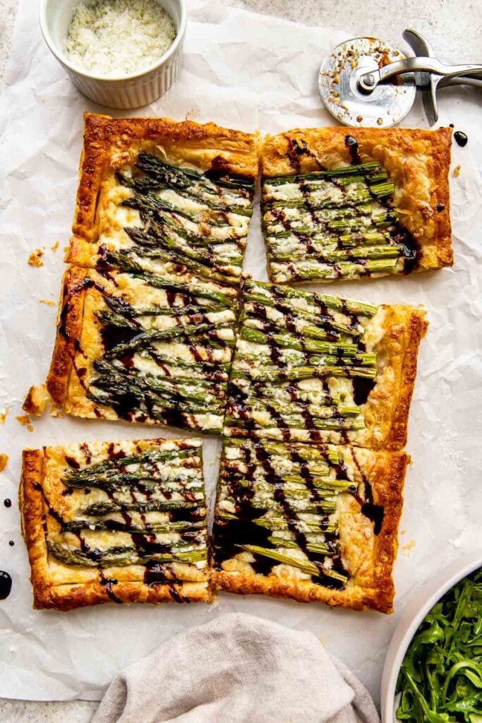 Puff pastry and asparagus tart with balsamic cut into squares.