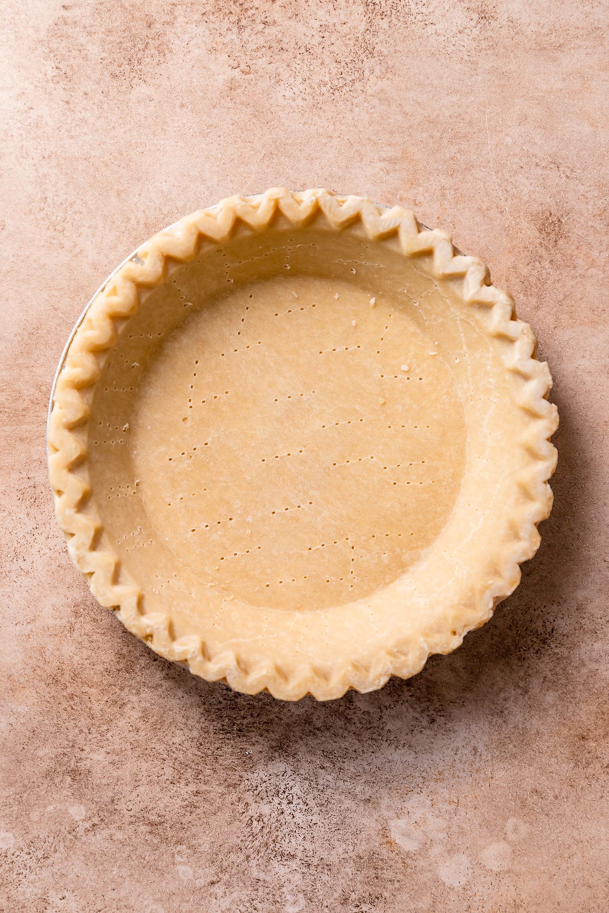 Rolled out pie dough in a pie dish.