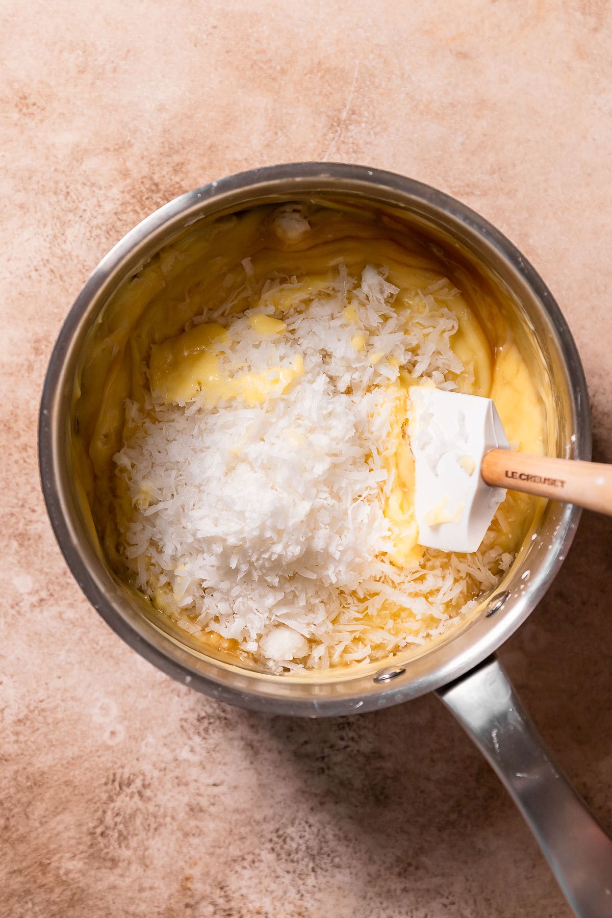 Stirring sweetened shredded coconut into custard filling.