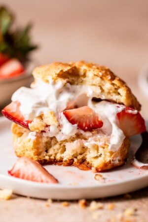 Bite taken out of strawberry shortcake.