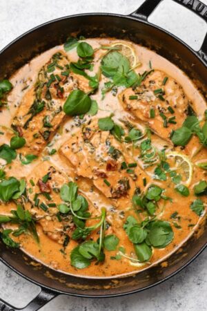 Marry me salmon in a skillet with fresh watercress.