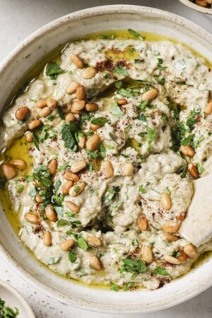 Easy homemade babaganoush in a bowl with toasted pine nuts.