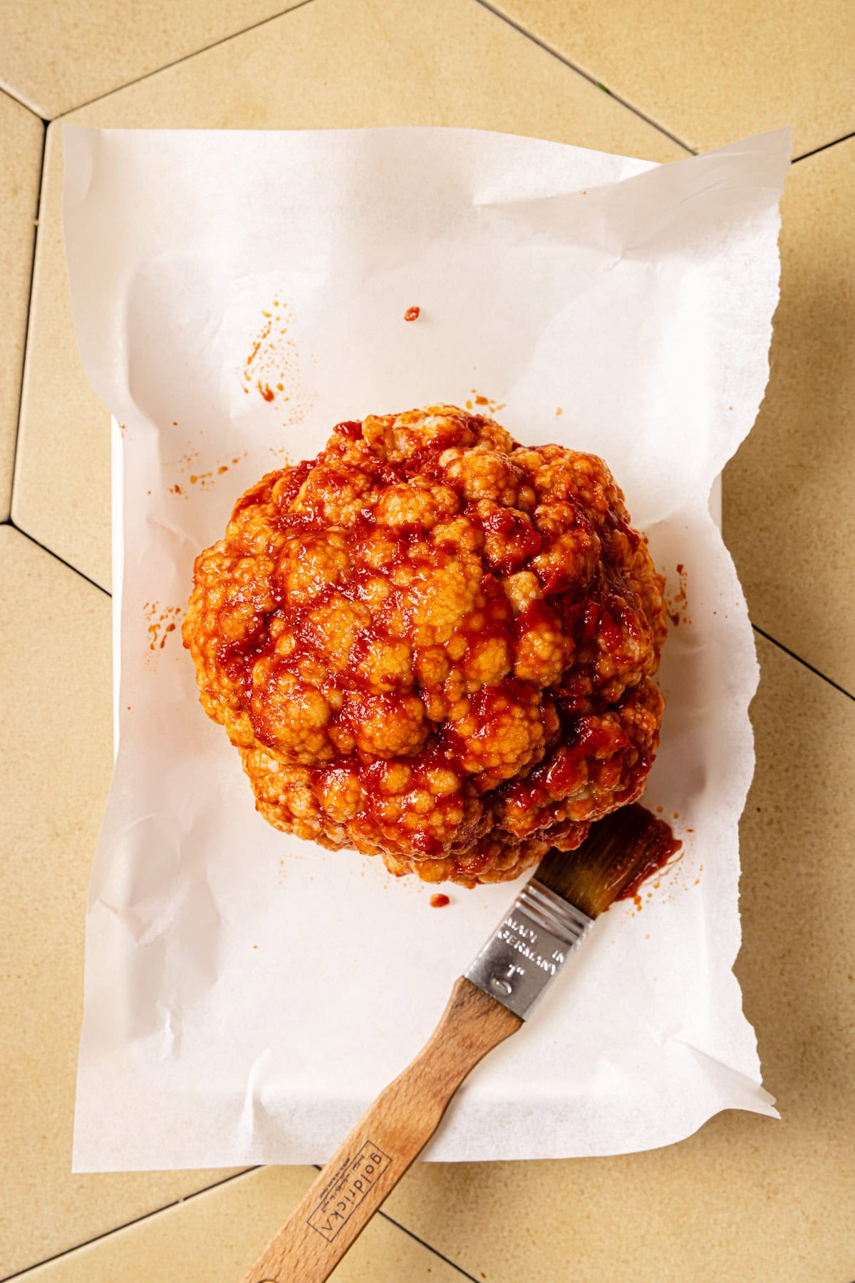 Brush head of cauliflower with tomato paste, olive oil and garlic powder.