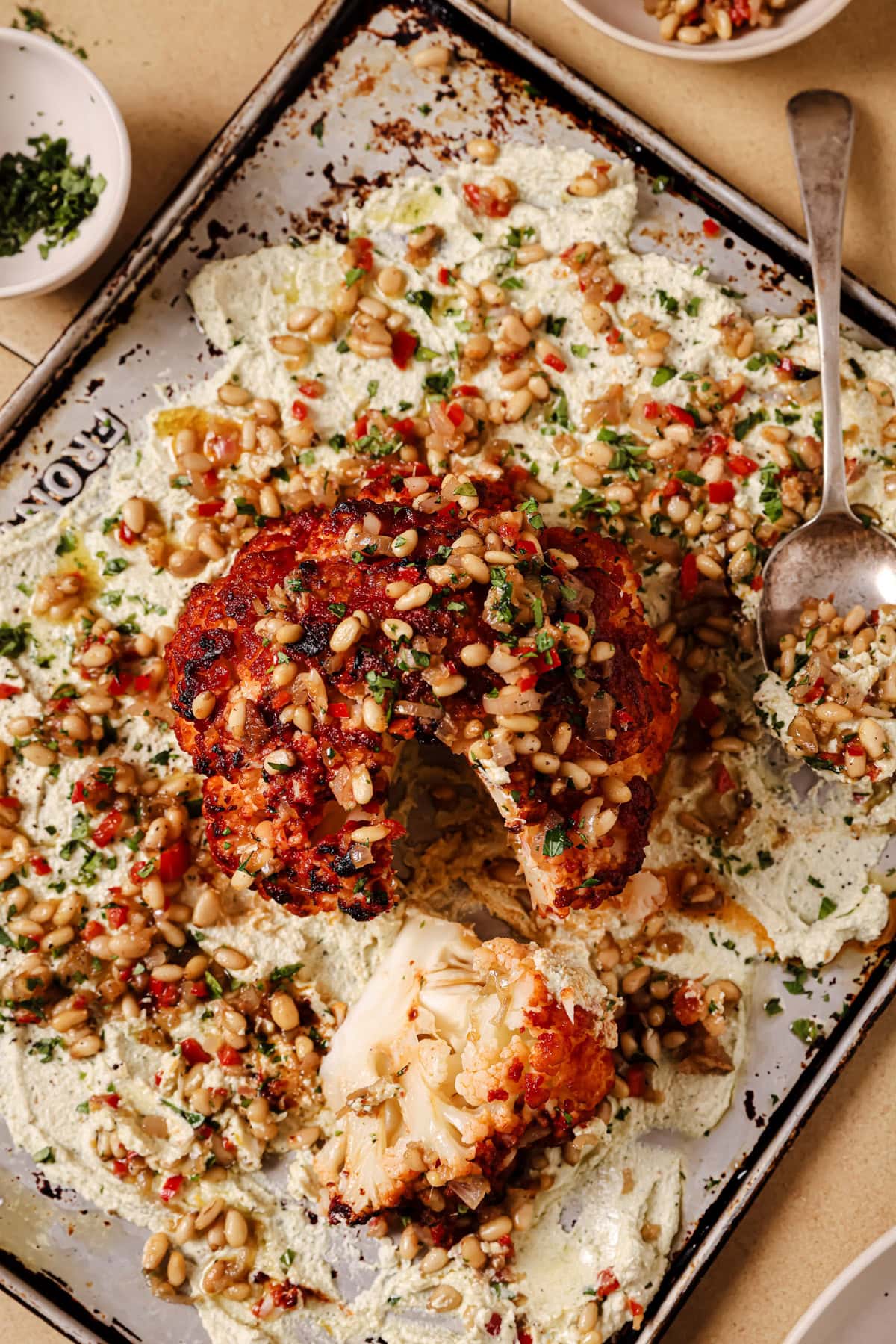 Whole head of roasted cauliflower with ricotta cheese and pine nuts.