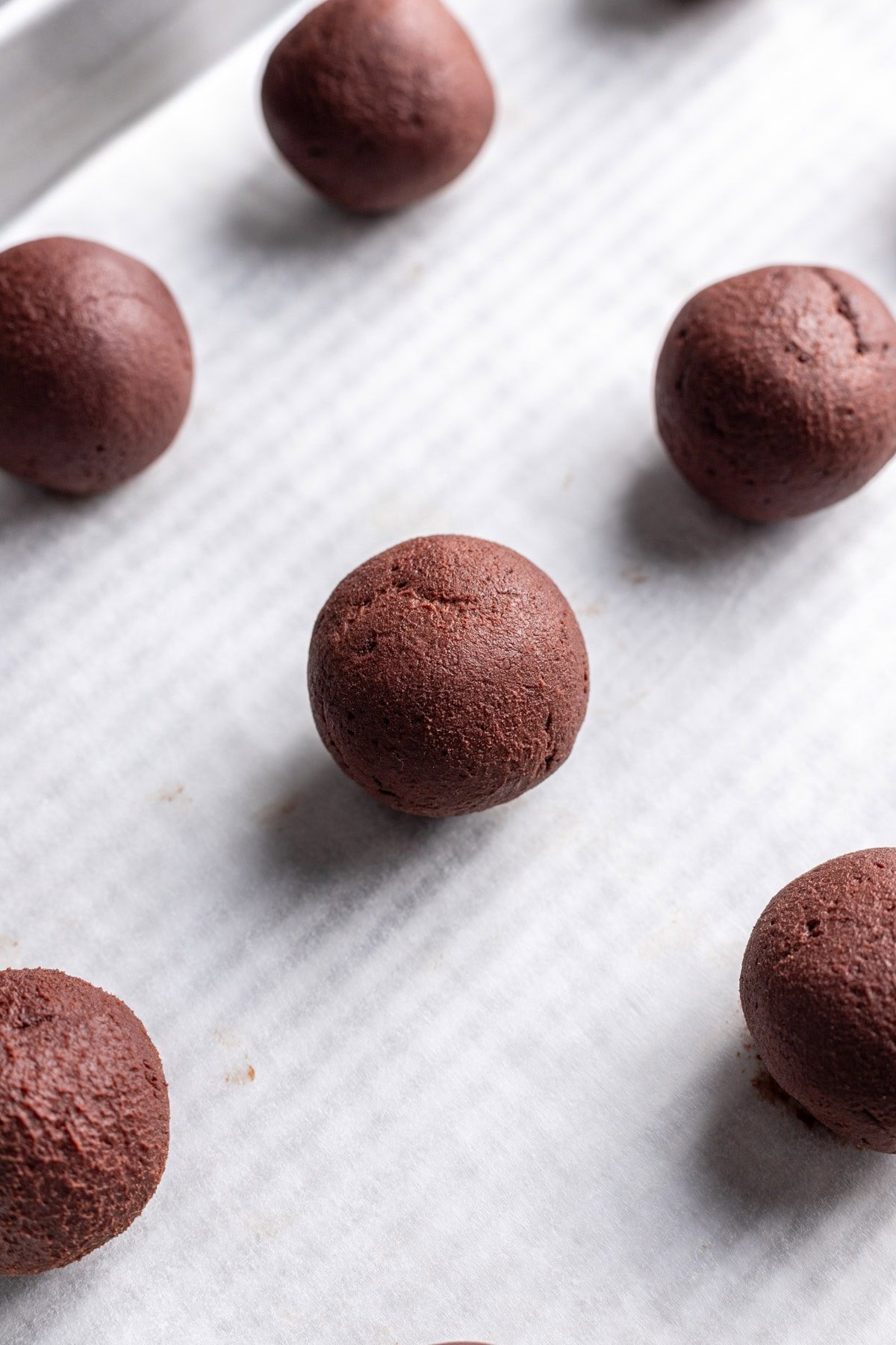 Chocolate ganache truffles on a sheet pan.