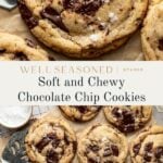 A batch of large, golden-brown chocolate chip cookies with melted dark chocolate chunks and a sprinkle of sea salt on top, arranged on parchment paper with a metal spatula nearby.
